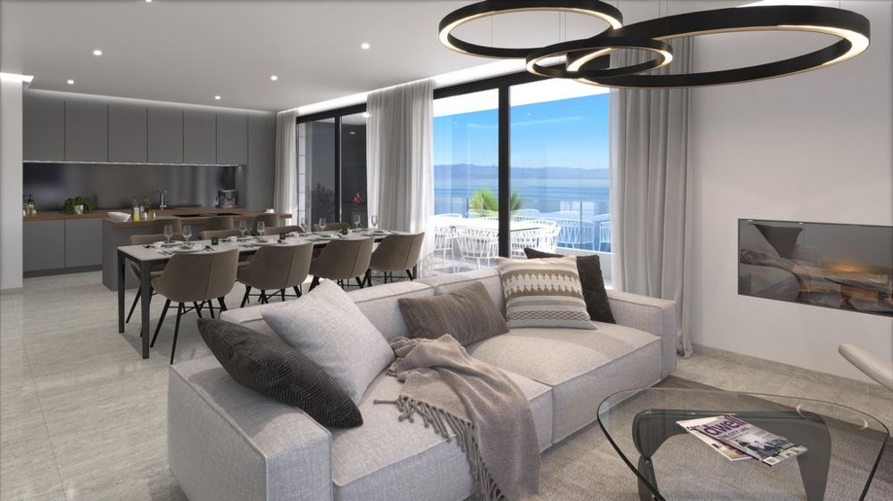 Otevřený obývací a jídelní kout s kuchyní a výhledem na moře