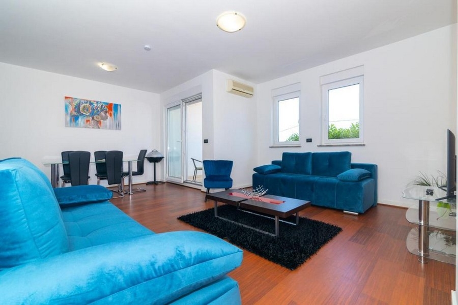 Zařízený obývací pokoj s výhledem na terasu.