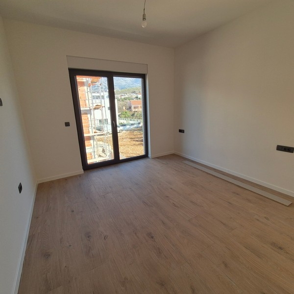 Světlá ložnice s dřevěnými podlahami