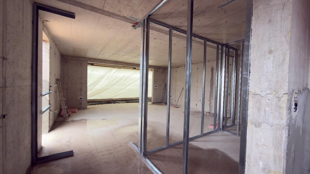 Otevřený obývací prostor v skořepině s velkým průčelím okna