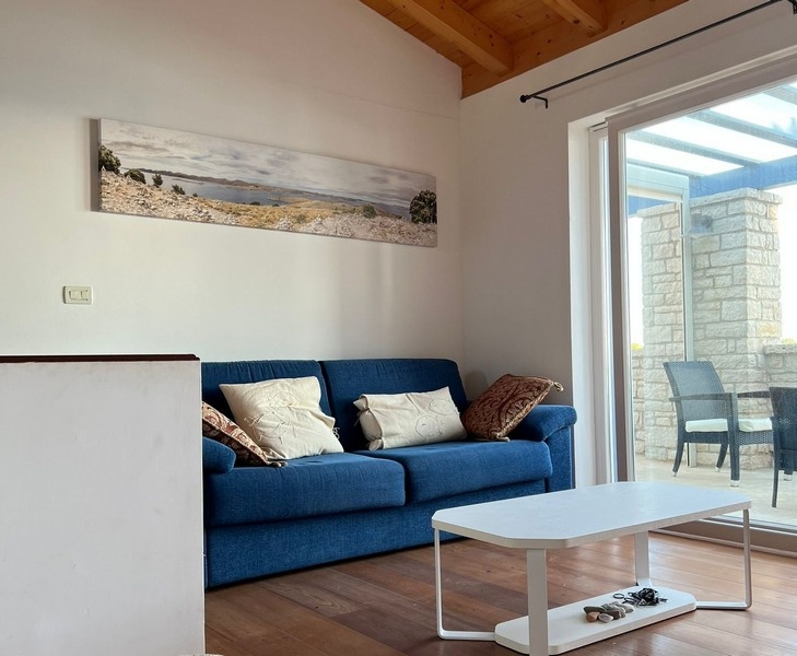 Obývací pokoj se sedací soupravou a vstupem na krytou terasu