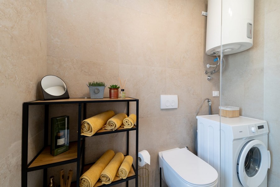 Moderní koupelna s pračkou a policí