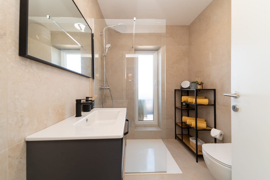 Koupelna se sprchovým koutem, umyvadlem a oknem