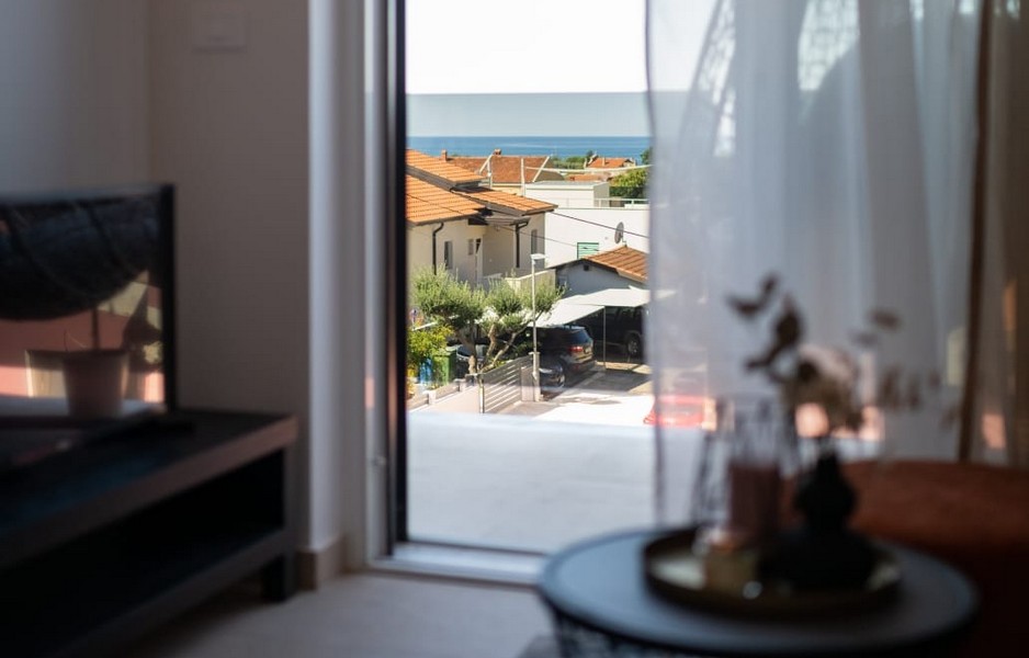 Pohled z obytné části na moře a sousední domy