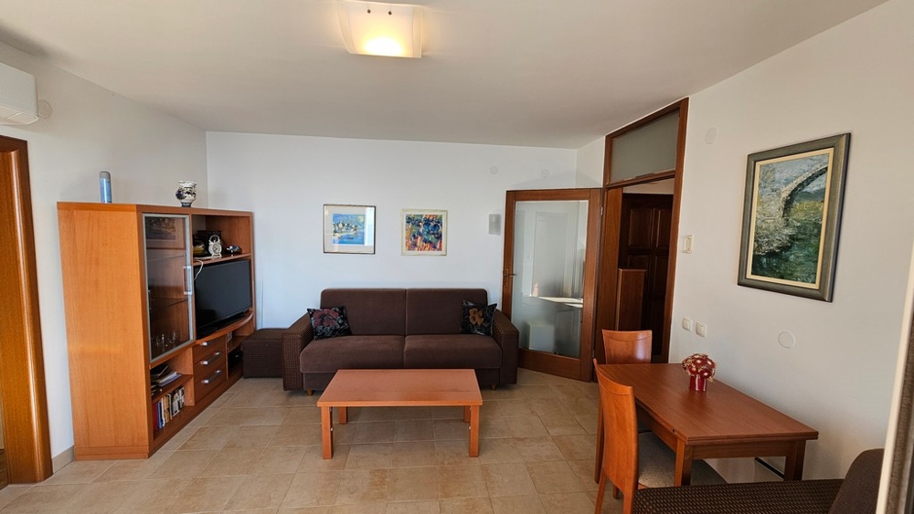 Obývací pokoj se sedací soupravou, TV nábytkem a jídelním koutem