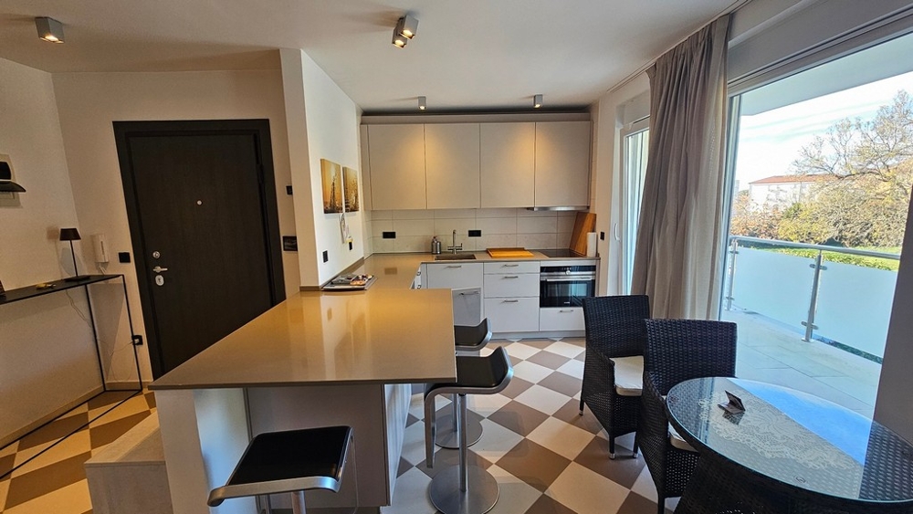 Moderní obývací a kuchyňský kout se vstupem na balkon