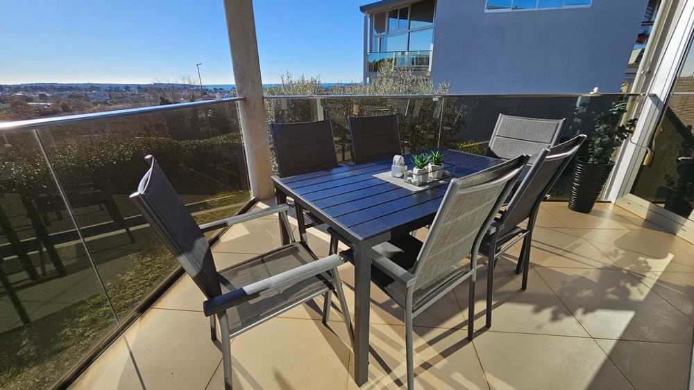 Krytá terasa s výhledem na moře a posezením