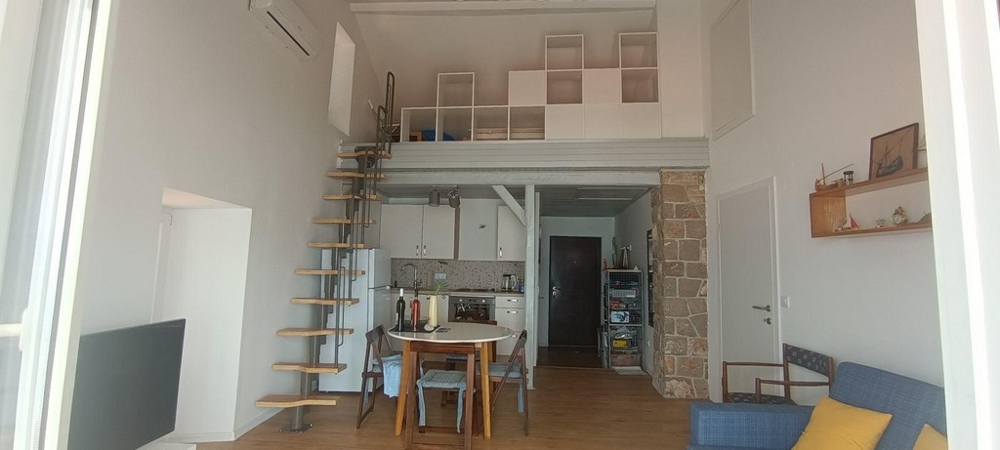 Obývací pokoj s galerií, schodištěm a integrovanou kuchyní