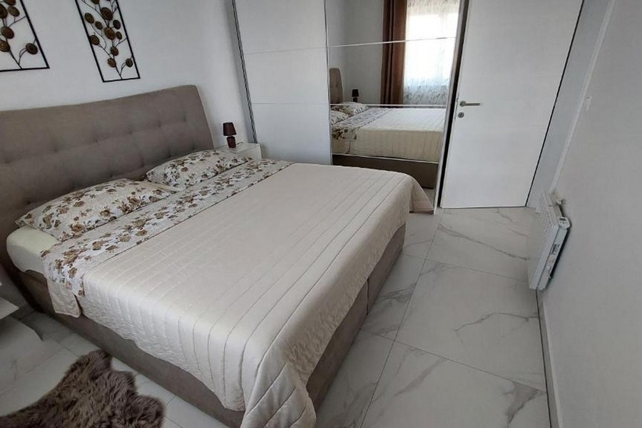 Ložnice s manželskou postelí a šatní skříní se zrcadlovými dveřmi