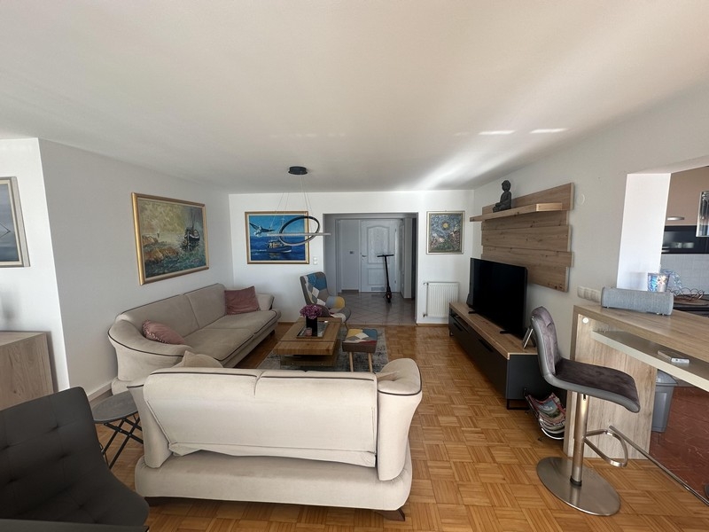 Obývací pokoj s pohovkou a otevřeným přechodem do kuchyně