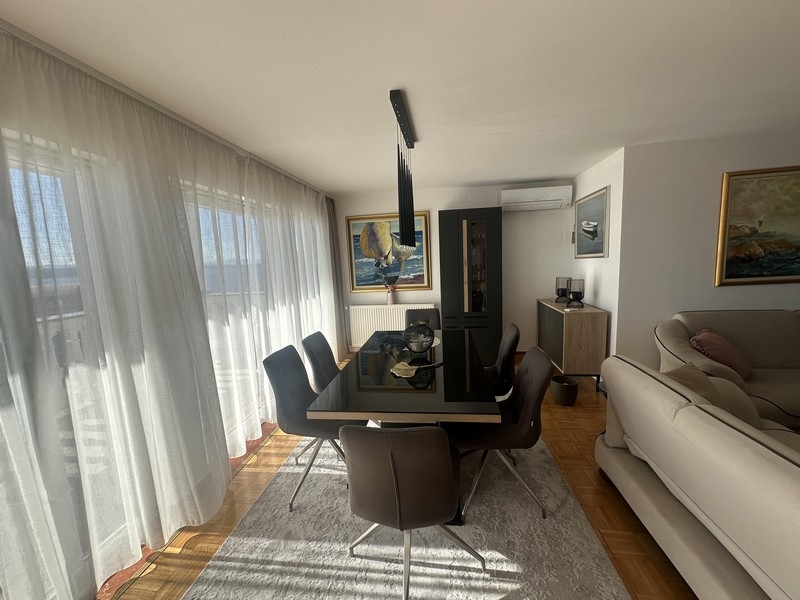 Jídelní kout se stolem a okny od podlahy ke stropu