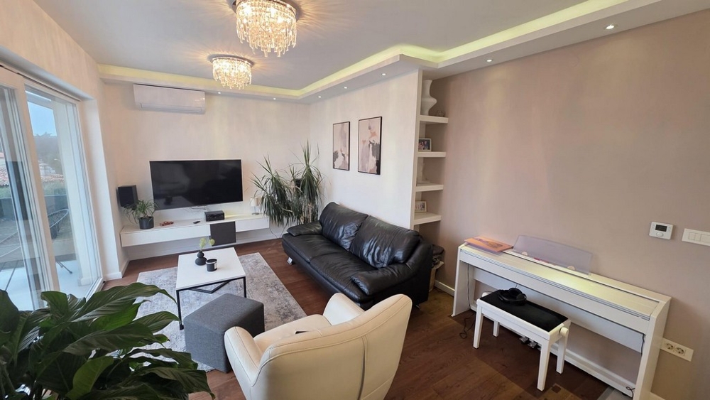 Moderní obývací pokoj s koženou pohovkou, klimatizací a nepřímým osvětlením