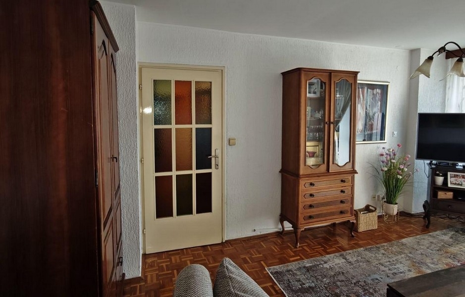 Obývací pokoj s parketami a klasickým dřevěným nábytkem