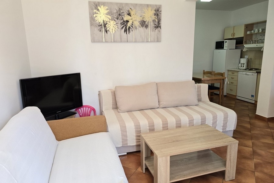 Obývací pokoj s pohovkou, konferenčním stolkem a televizí