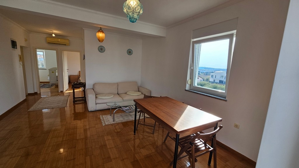 Obývací pokoj s jídelním stolem a výhledem na moře v Novigradu