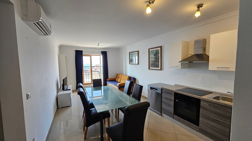 Světlý obývací pokoj s otevřenou kuchyní, jídelním koutem a výhledem na moře