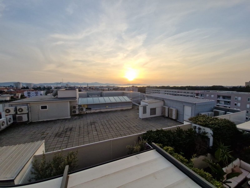 Výhled na moře nad městem při západu slunce