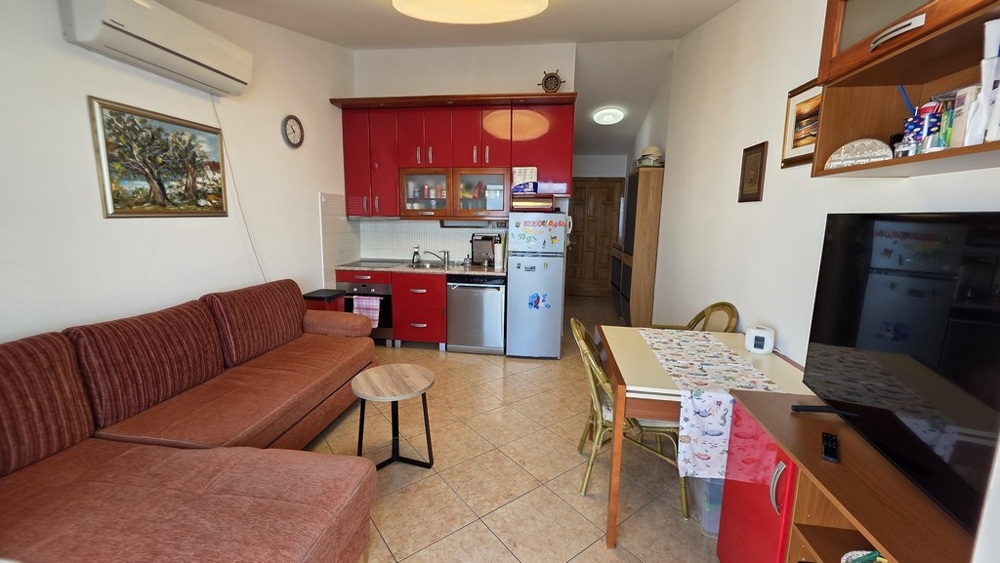 Obývací pokoj s pohovkou a otevřenou kuchyní