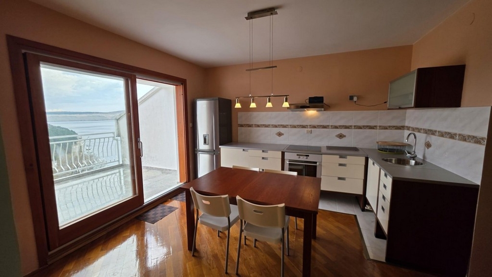 Otevřená kuchyně s vestavěnými spotřebiči a jídelním koutem