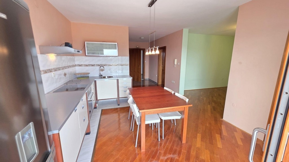 Obývací pokoj s kuchyní a výhledem do chodby