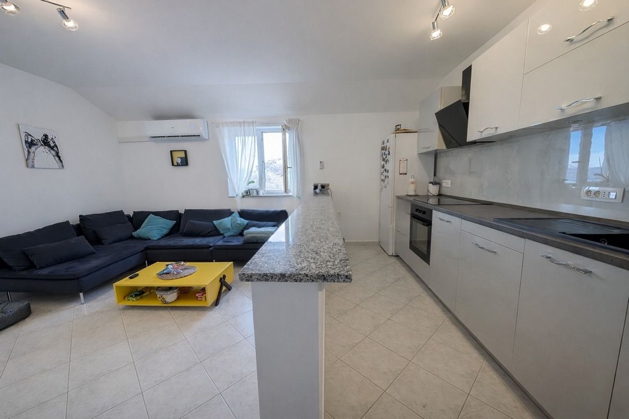 Moderní obývací pokoj s otevřenou kuchyní a pohovkou