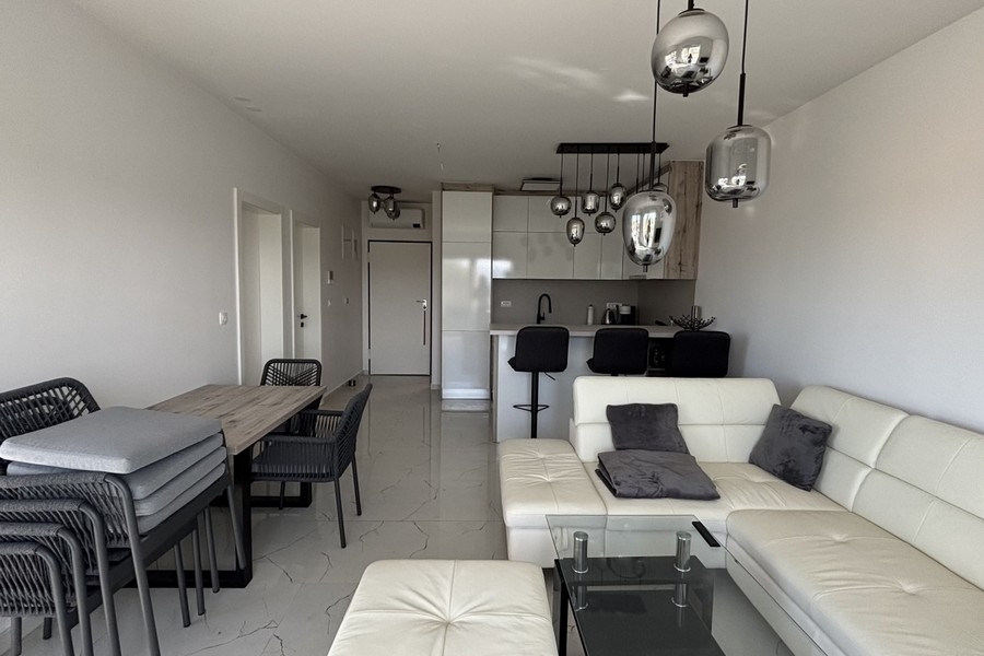 Moderní obývací prostor s otevřenou kuchyní a posezením