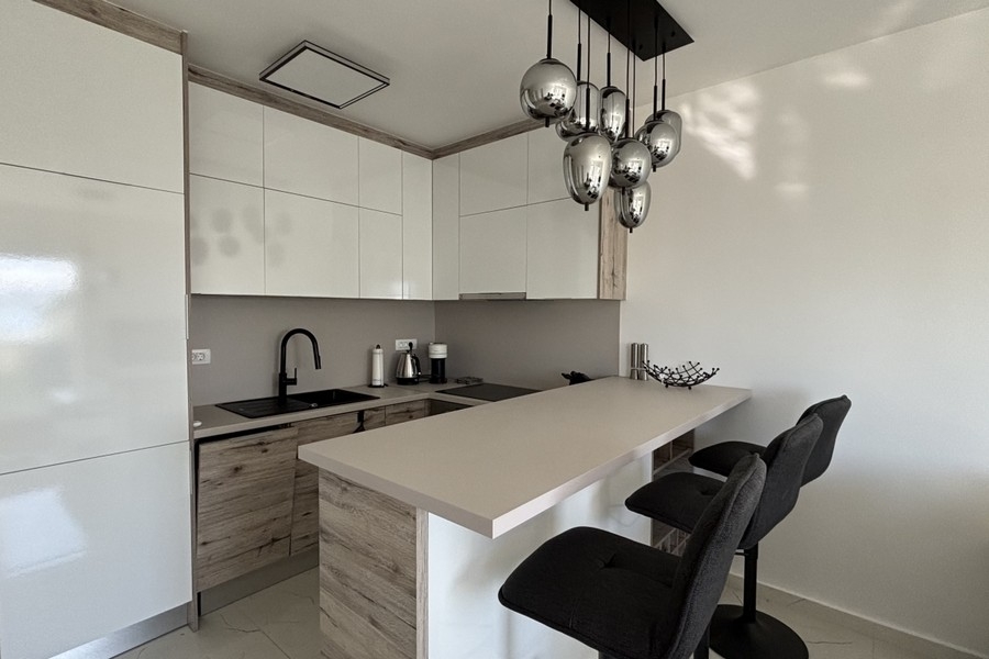 Moderní kuchyně s ostrůvkem a barovými židlemi