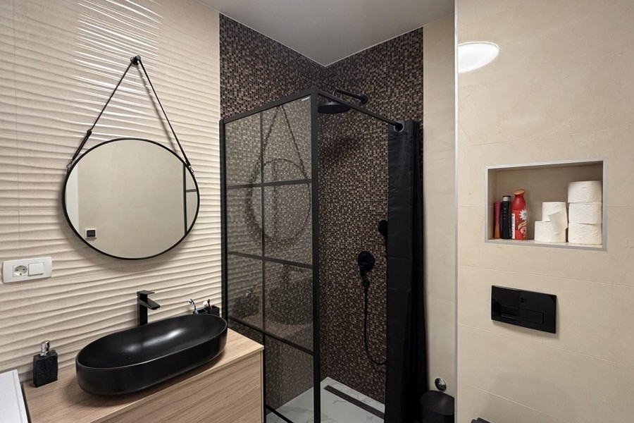 Moderní koupelna se sprchovým koutem a umyvadlem