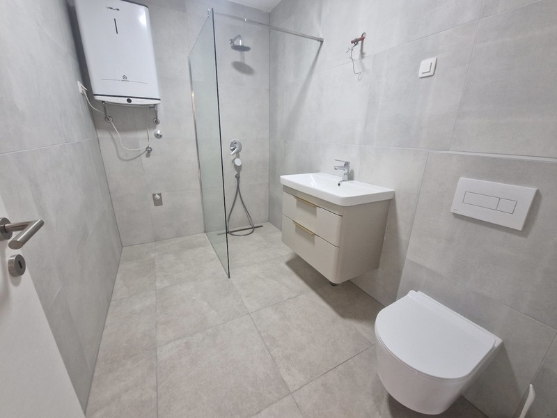 Moderní koupelna se sprchovým koutem a umyvadlem