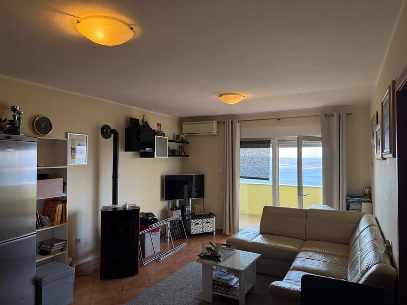 Obývací pokoj s TV a vstupem na balkon