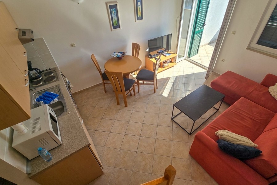 Světlý obývací pokoj s otevřenou kuchyní a vstupem na balkon