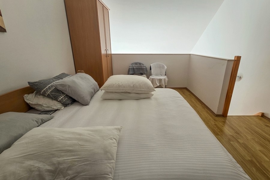 Ložní část na galerii s manželskou postelí a šatní skříní