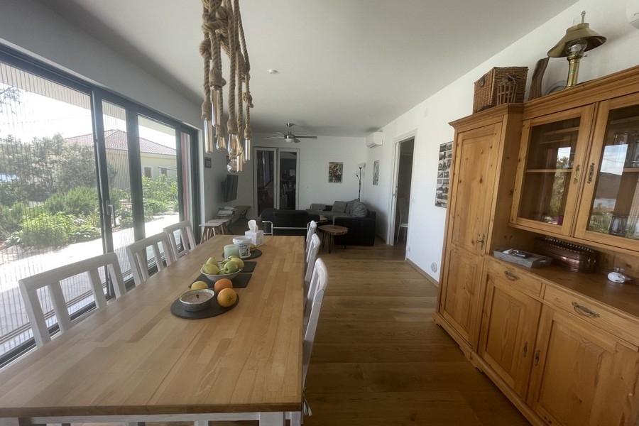 Otevřený obývací a jídelní kout s velkými okny a výhledem do krajiny