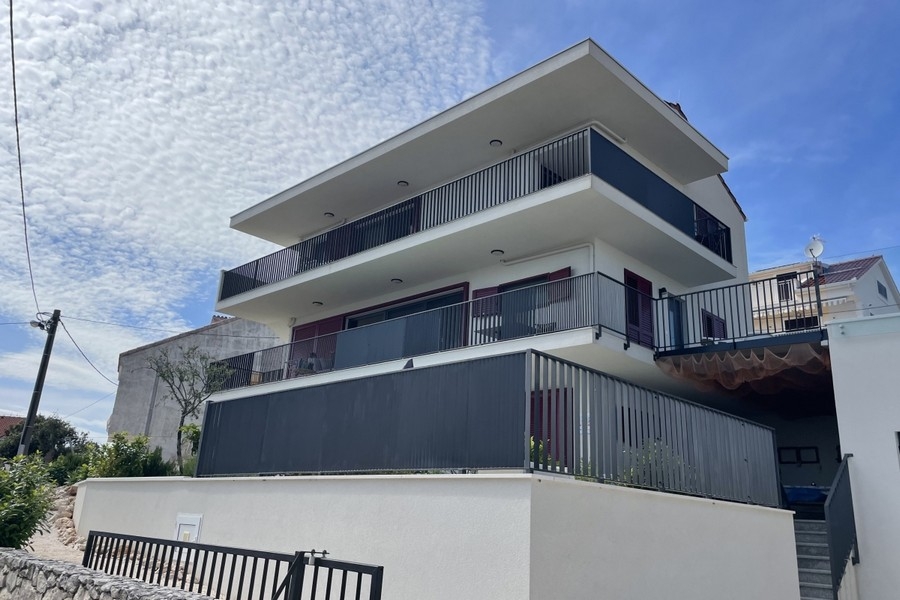 Světlý obývací a jídelní kout s velkými okny a výhledem na moře