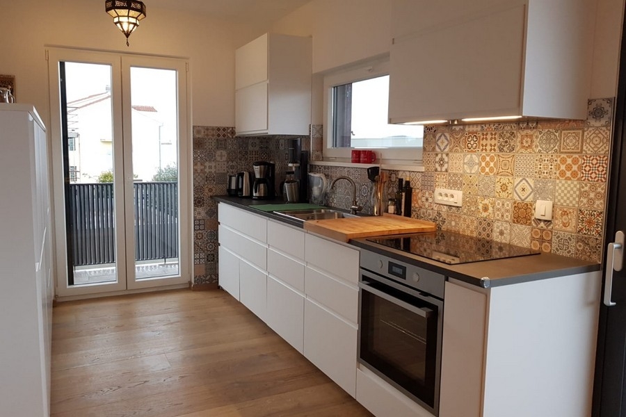 Moderní kuchyňská linka s vestavěnými spotřebiči a dekorativní obklady