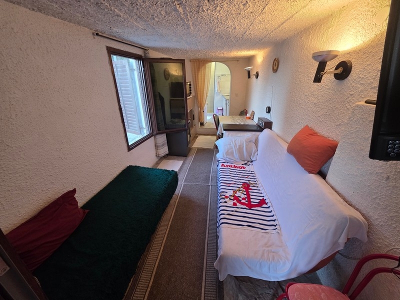 Úzký obývací pokoj s posezením a oknem do ulice