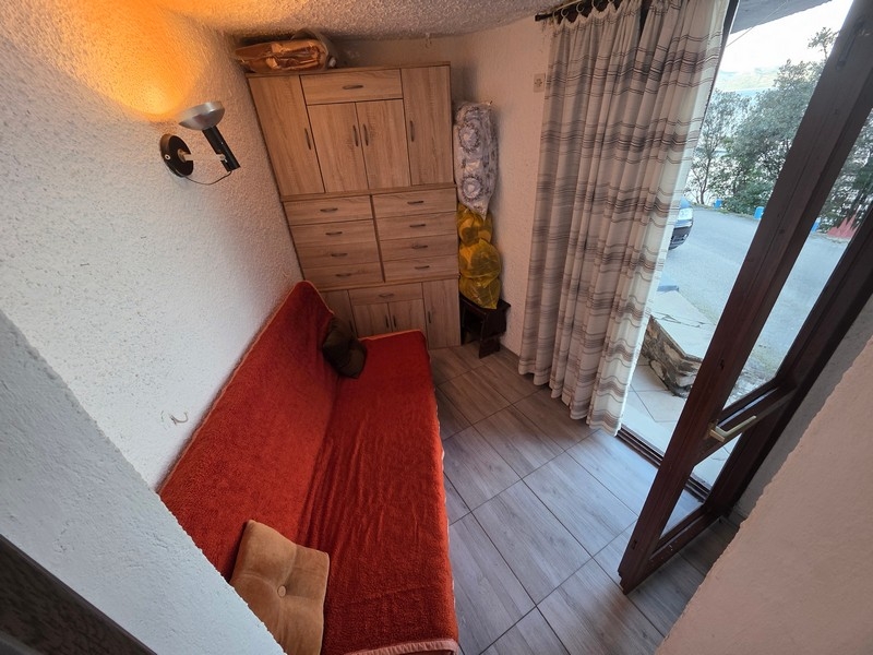 Malý obývací prostor s pohovkou a přístupem ven