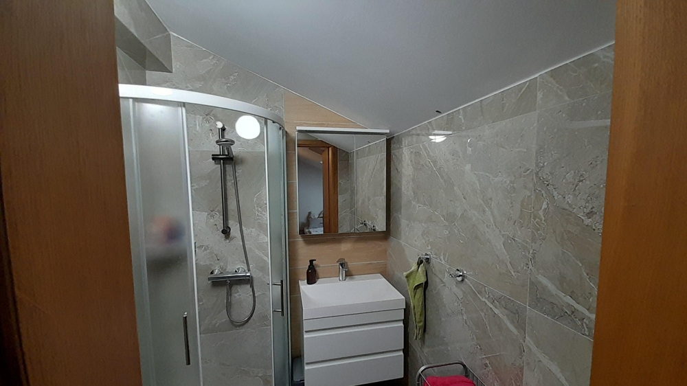 Moderní koupelna se sprchovým koutem a umyvadlem