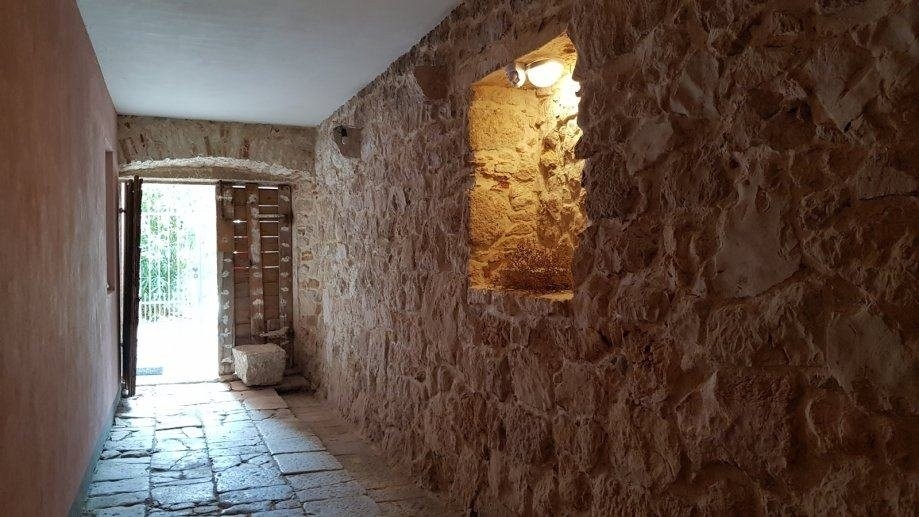 Předsíň s přírodní kamennou zdí a východem na terasu