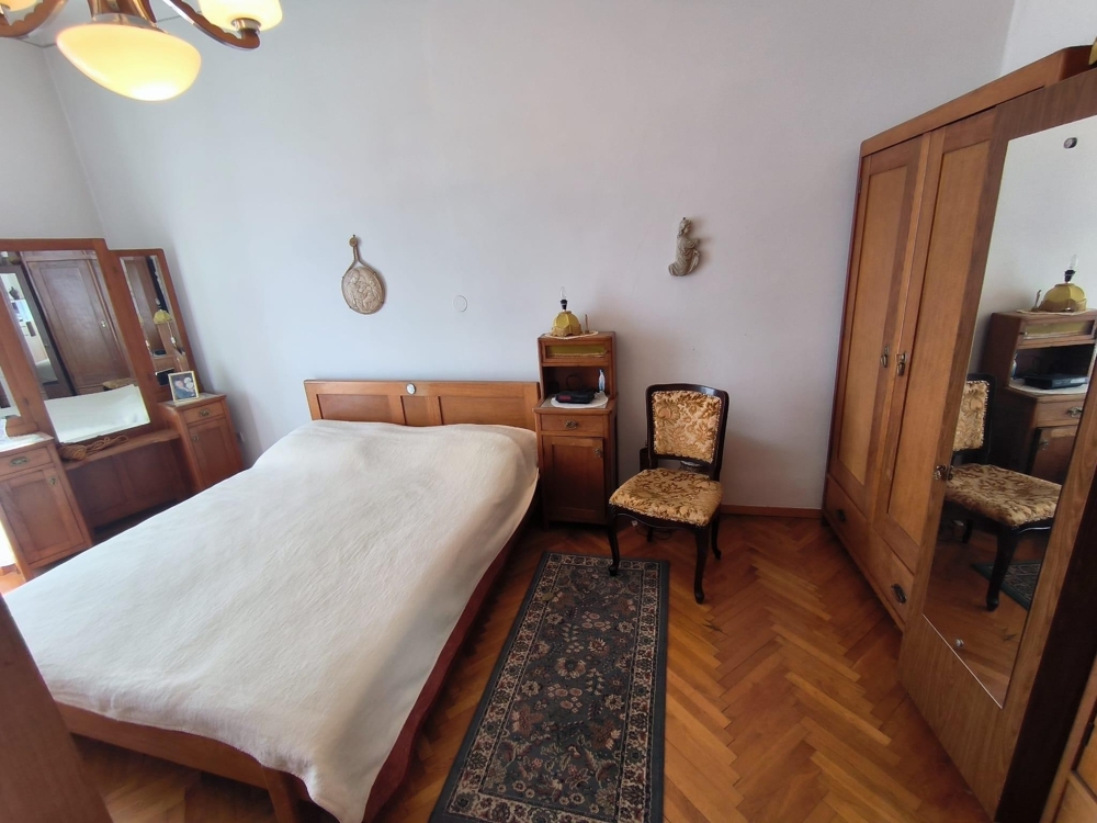 Ložnice s oknem a klasickým nábytkem