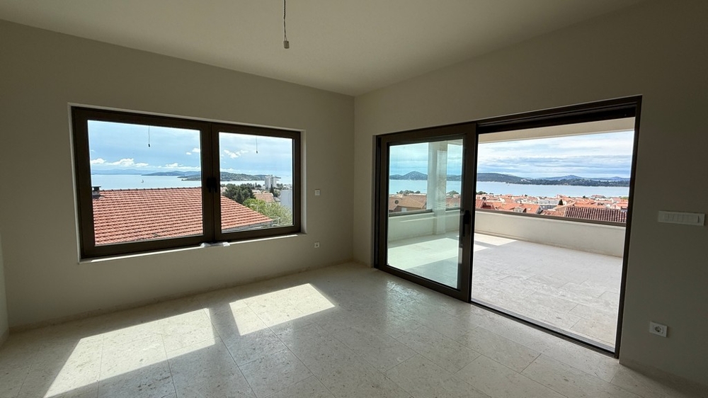 Otevřený obývací prostor s výhledem na moře a vstupem na terasu