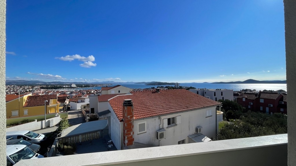 Výhled na moře z balkonu přes střechy a pobřeží