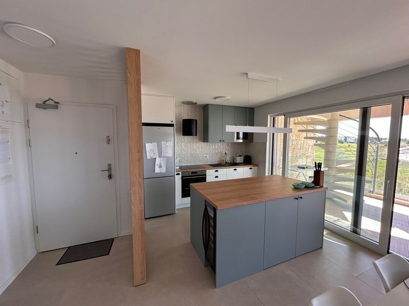 Obývací pokoj s otevřenou kuchyní a vstupem na terasu