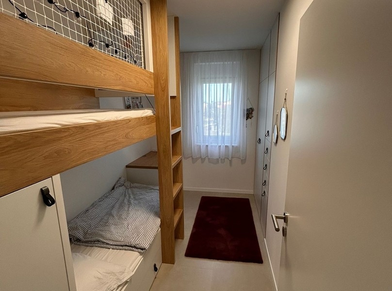 Dětský pokoj s patrovou postelí a vestavěnými skříněmi