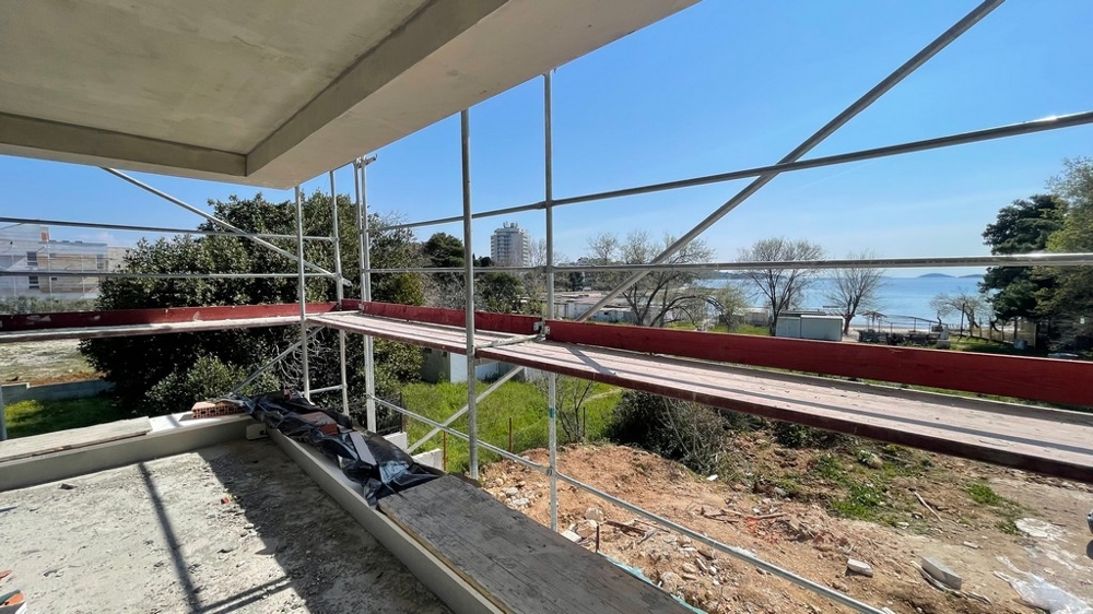 Balkon s lešením a výhledem na moře v Dalmácii.