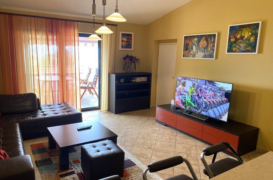 Obývací pokoj s pohovkou a balkonem v rekreačním apartmánu na Krku