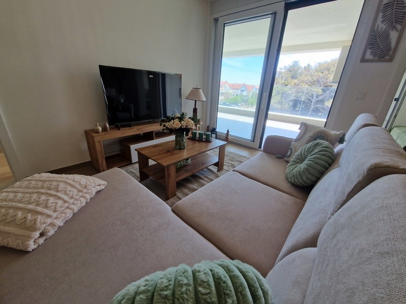 Obývací pokoj s velkým předním oknem a vstupem na balkon