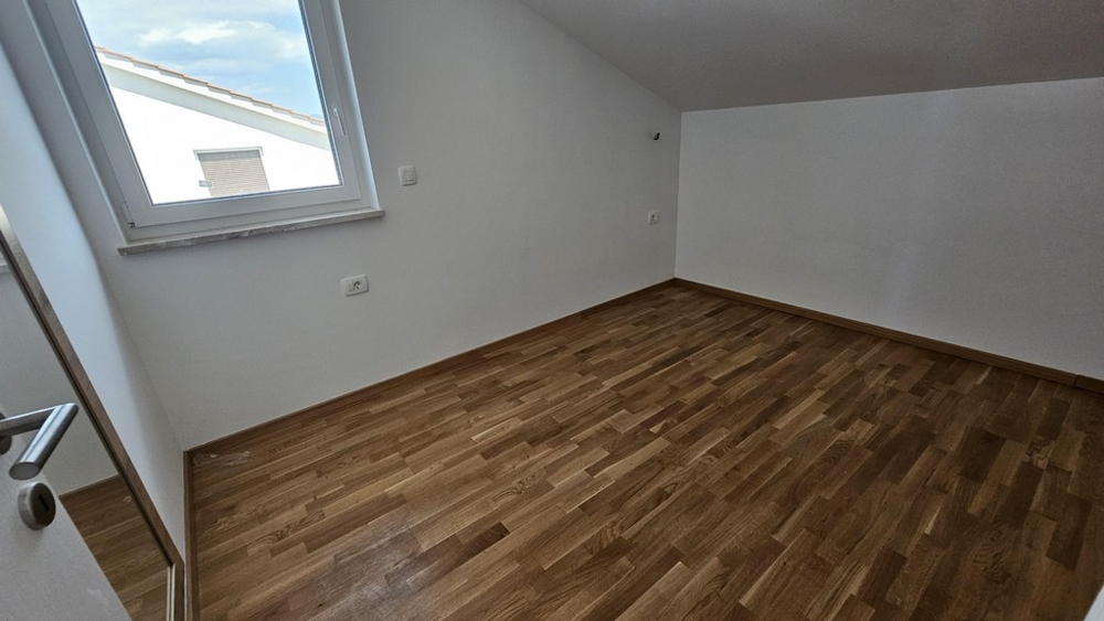 Ložnice se střešním oknem a parketami
