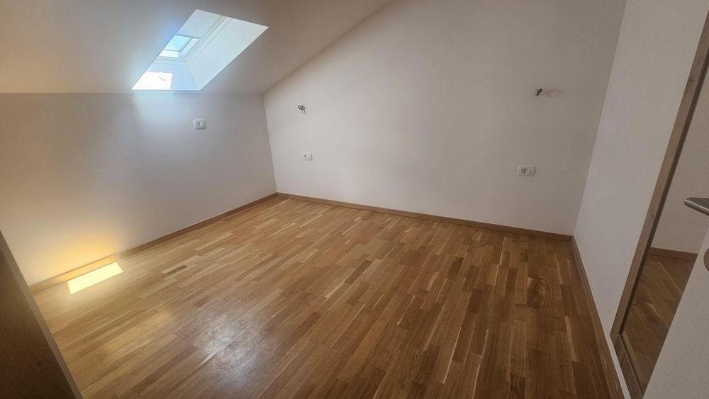Pokoj se světlíkem a dřevěnou podlahou