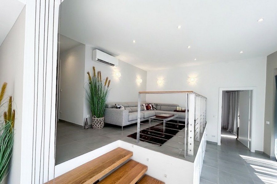 Vyvýšený obývací prostor s pohovkou a dřevěnými schody, apartmán Korčula